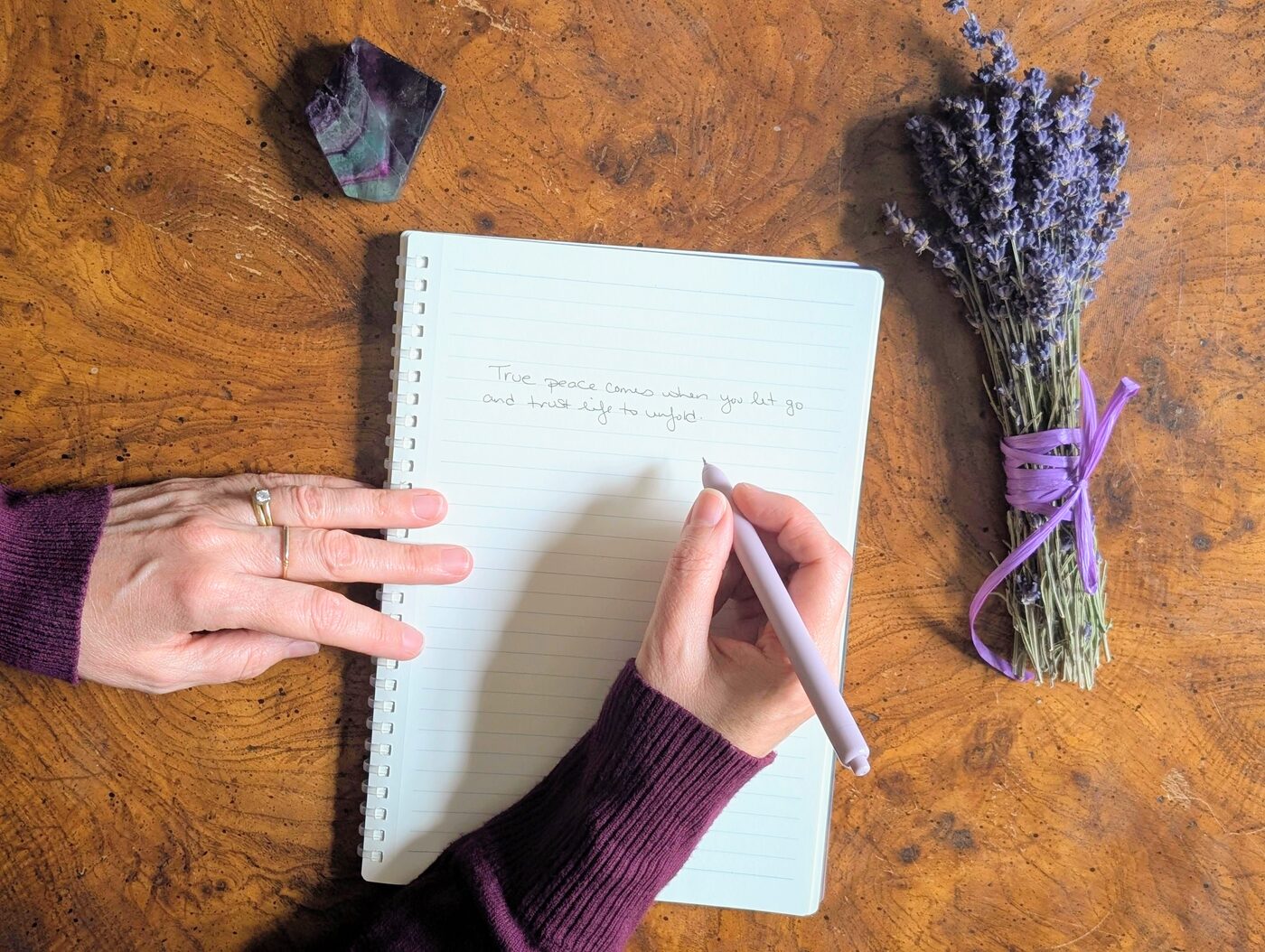 Hands writing in journal with lavender